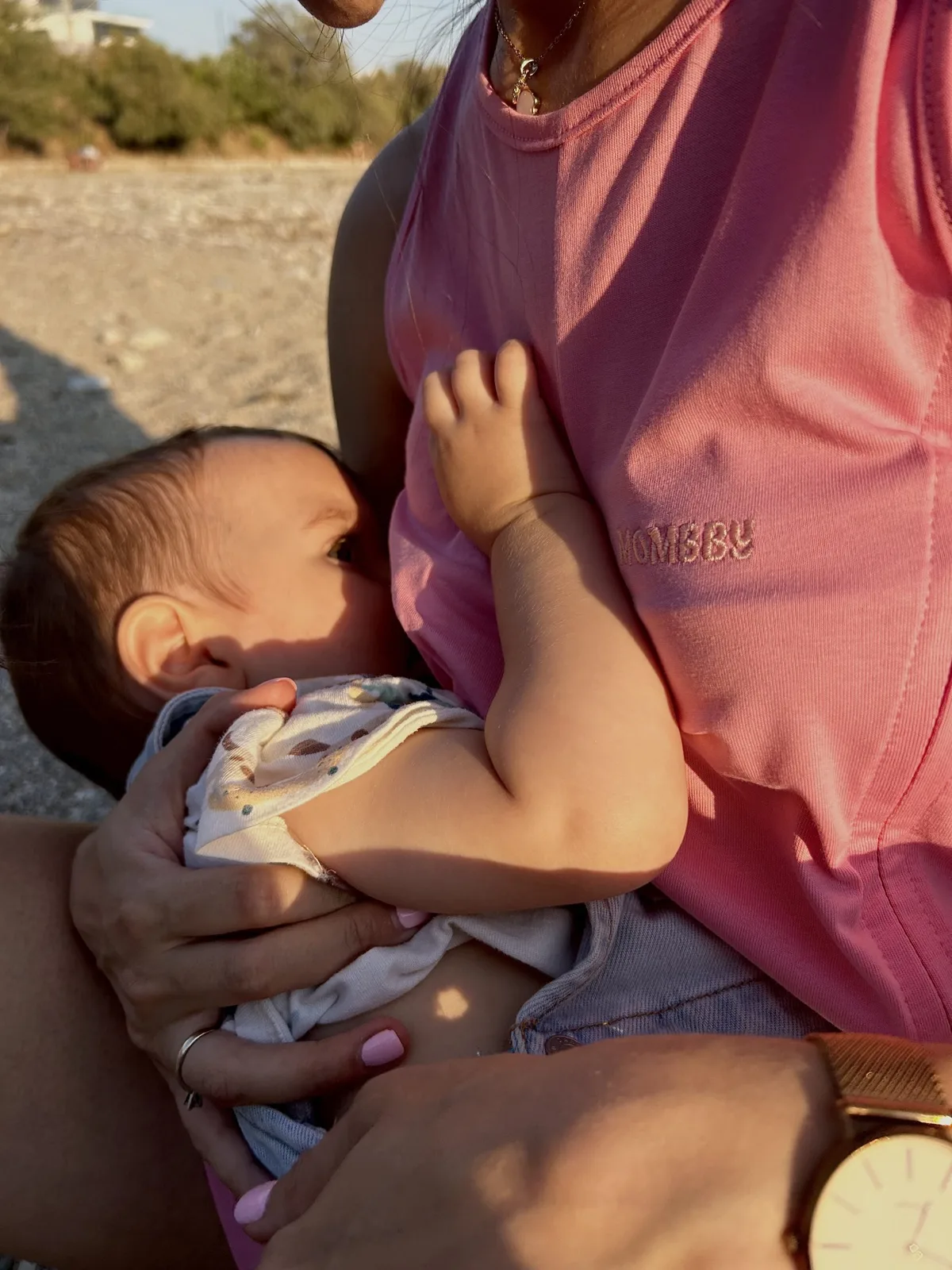 A mom nursing her baby in a Mombby nursing jumpsuit