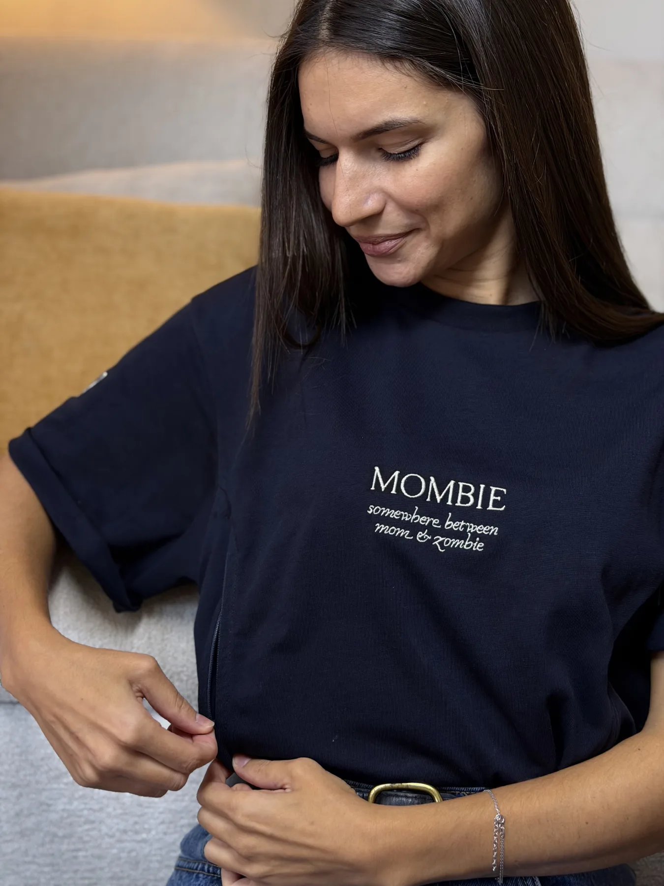A mom in an embroidered Mombie nursing tee