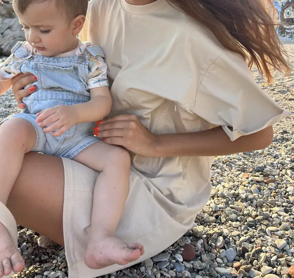 A mom nursing her baby in a Mombby nursing jumpsuit